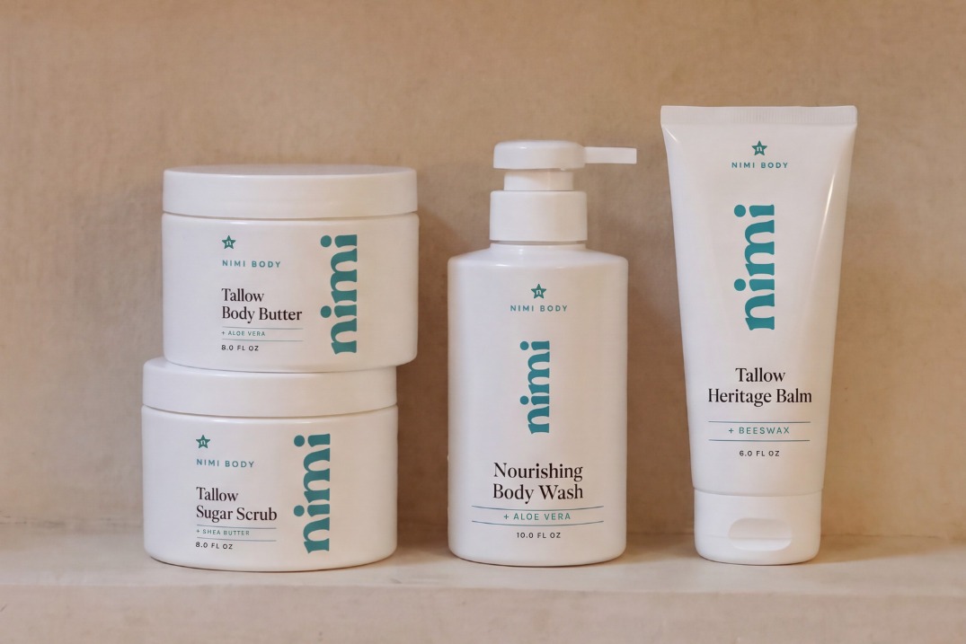 The full Nimi Body line arranged in a tiled shower niche: Tallow Body Butter, Tallow Sugar Scrub, Nourishing Body Wash, and Tallow Heritage Balm