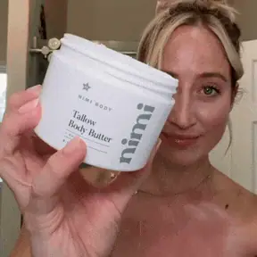 Scooping the Tallow Body Butter and applying it to the shoulder