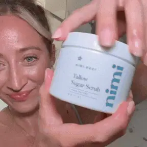 Scooping the Tallow Sugar Scrub and working it over the arm